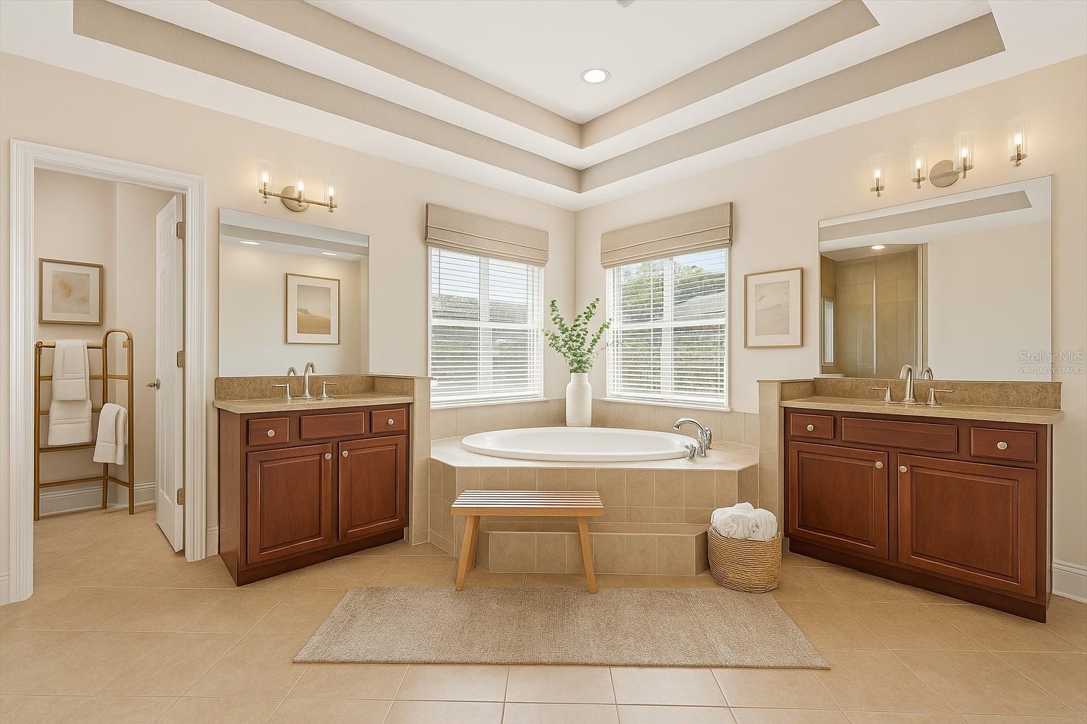 Master bath with sitting tub, dual vanities, large walk in closet at rear and virtually staged