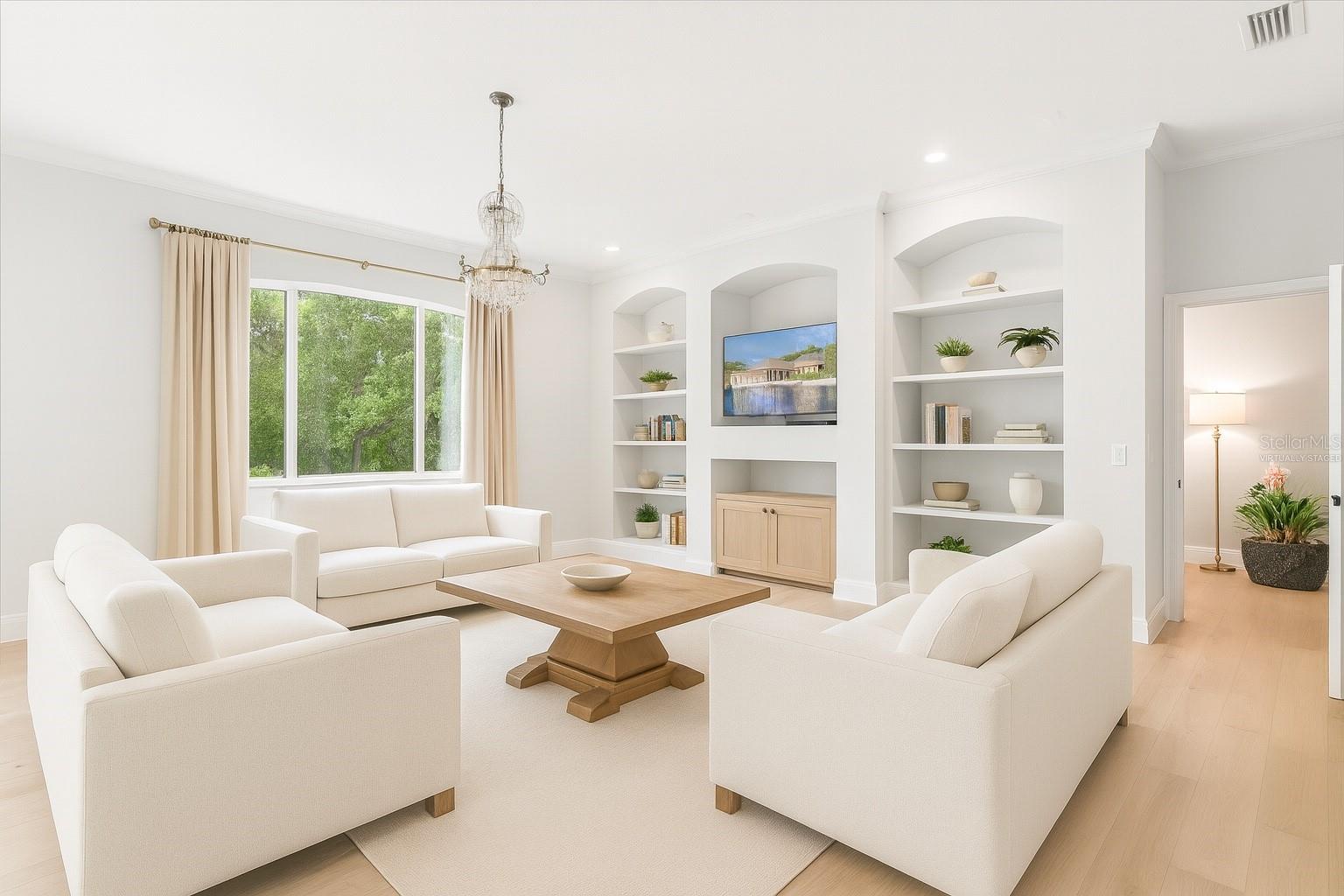 Other view of living room with entrance in corner to movie theater and game room and virtually staged