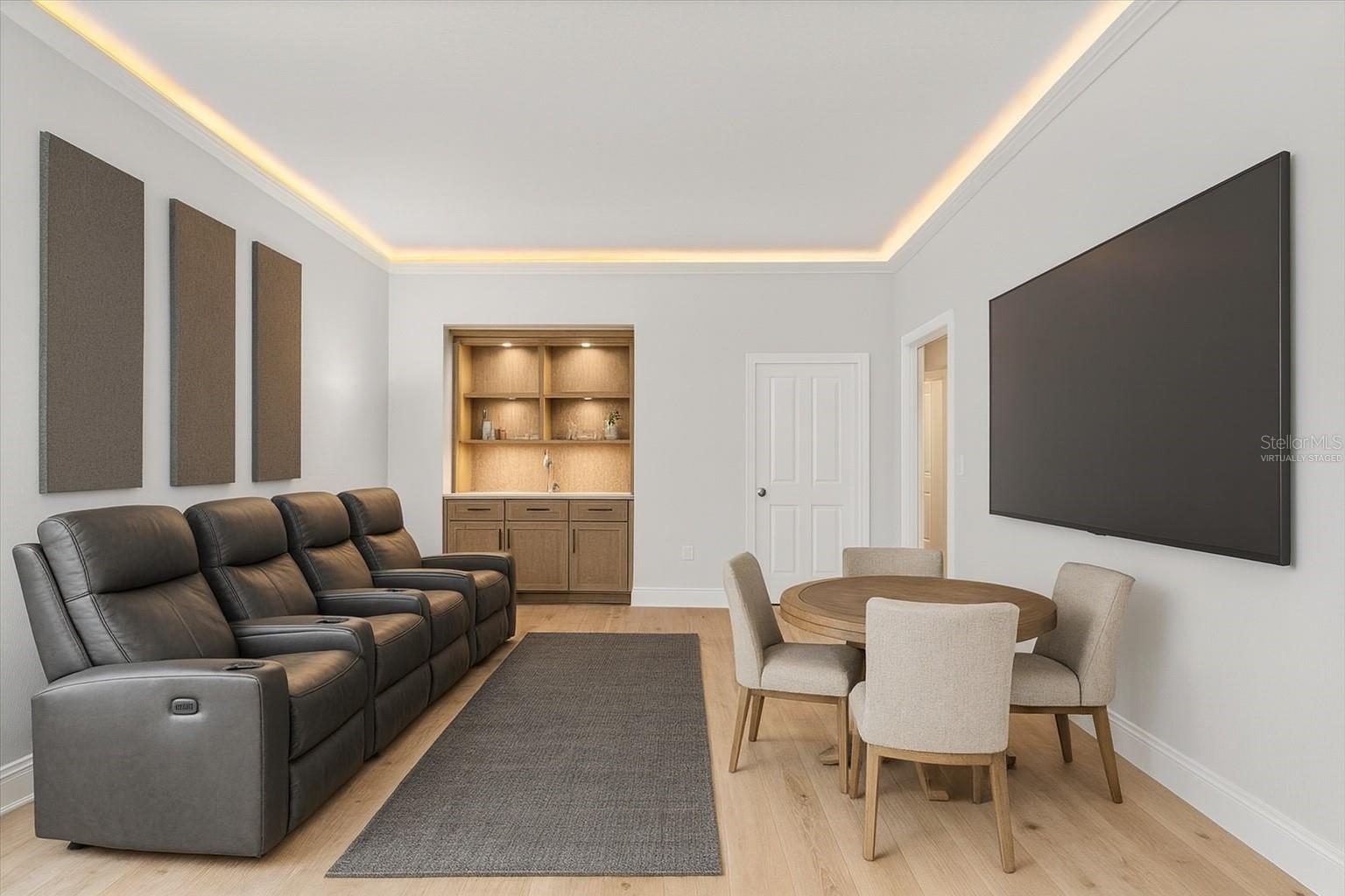 1st floor media room / movie theater / game / poker room with card table and potential bar cabinet adjacent to large open floor plan living room and virtually staged