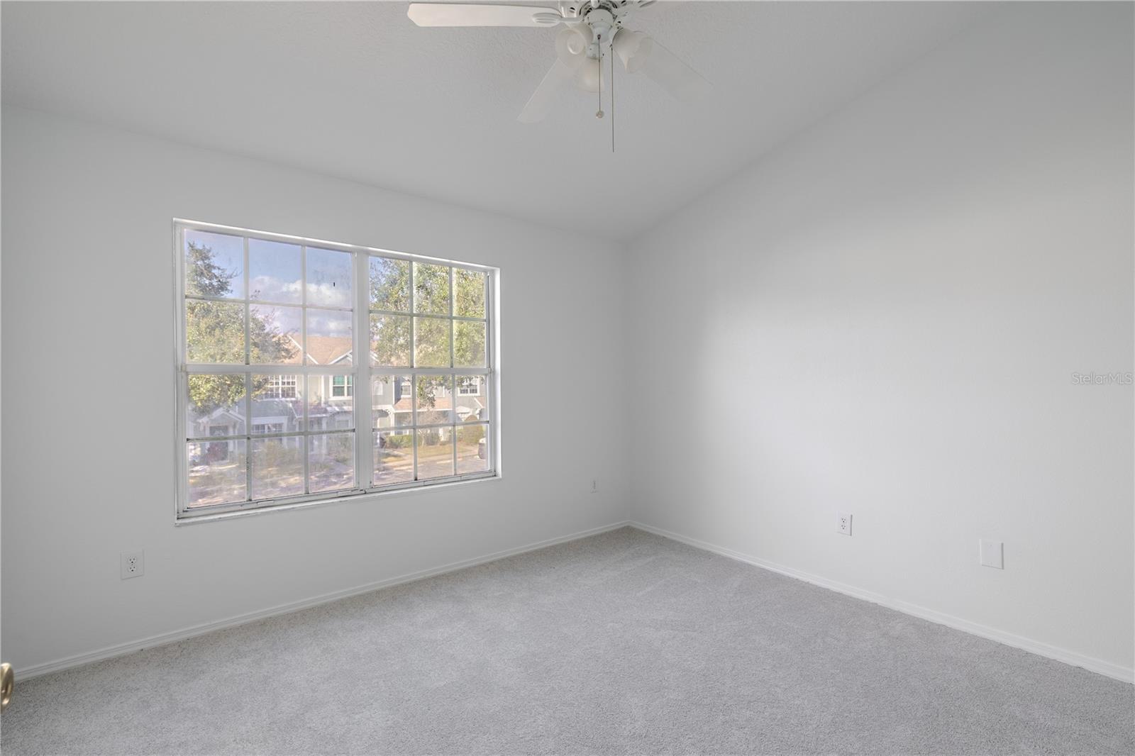 The 2nd bedroom features carpet, a ceiling fan with light kit and vaulted ceiling.