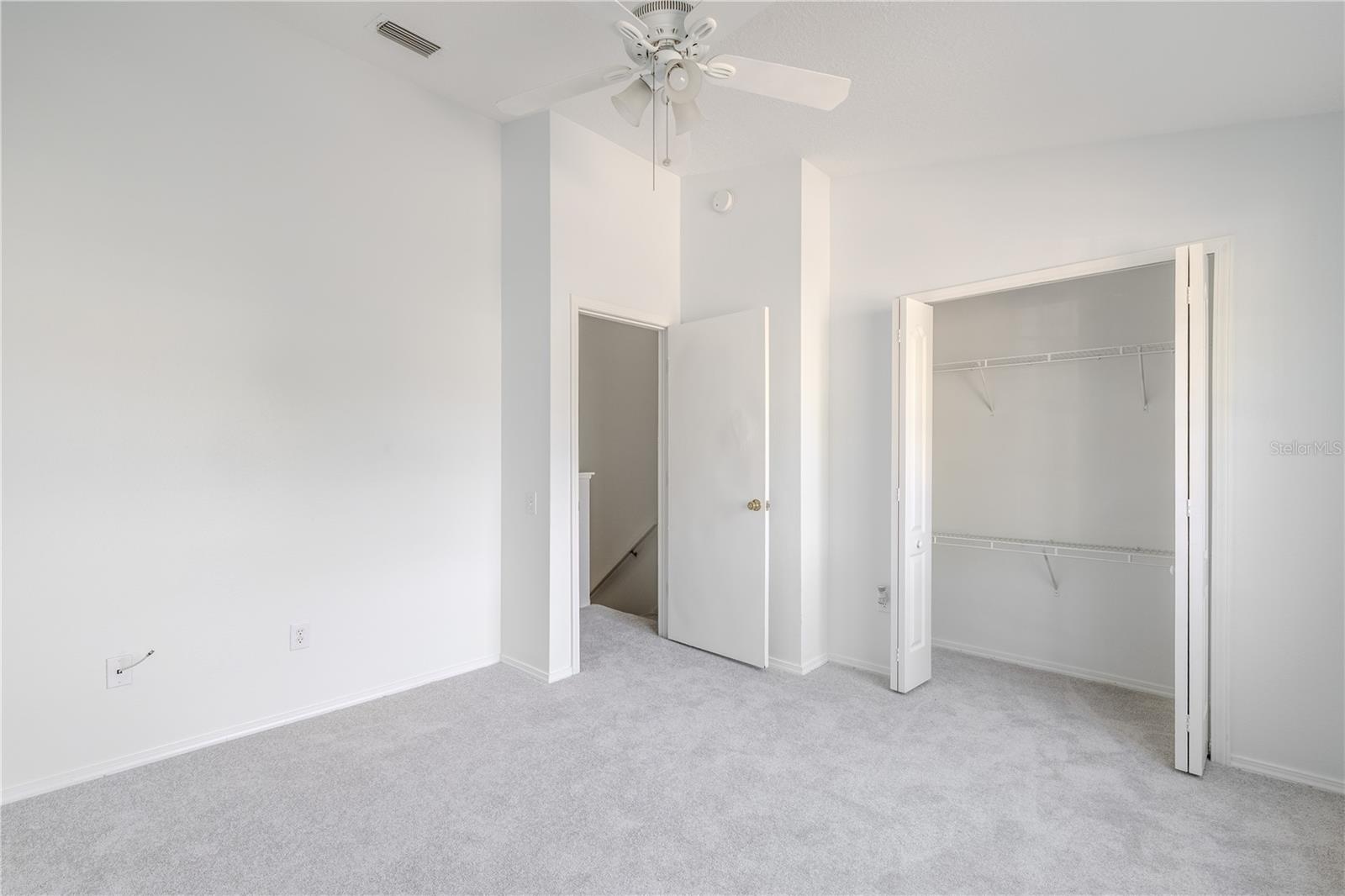 The 2nd bedroom features carpet, a ceiling fan with light kit and vaulted ceiling.