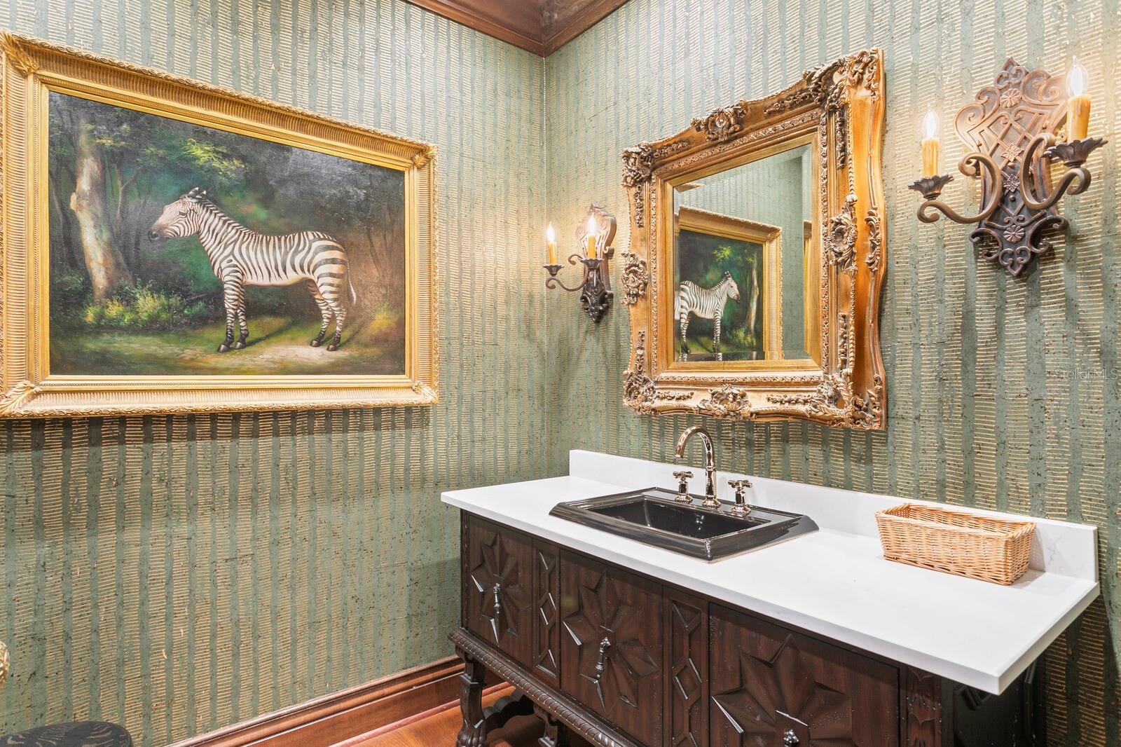 he deep, dark vanity pairs exquisitely with the sophisticated antique lighting, creating a cozy atmosphere.