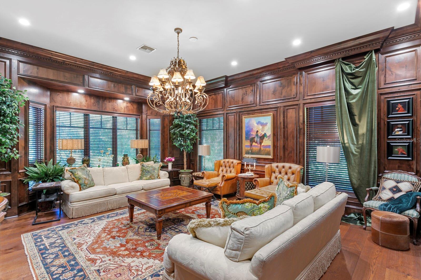 Adorned with rich wooden paneling and a grand chandelier that exudes timeless sophistication, this office invites you to lose yourself in the pages of your favorite novels and deep dive into productivity.