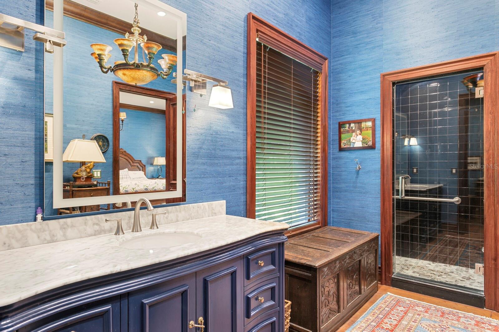 The marble-topped vanity exudes luxury, while well-placed lighting fixtures promise the perfect ambiance for your morning routine.