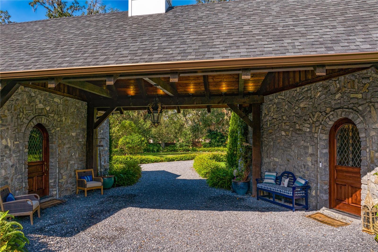 Beneath the beautiful porte-cochere, the rich, wood-paneled doors beckon you inside.