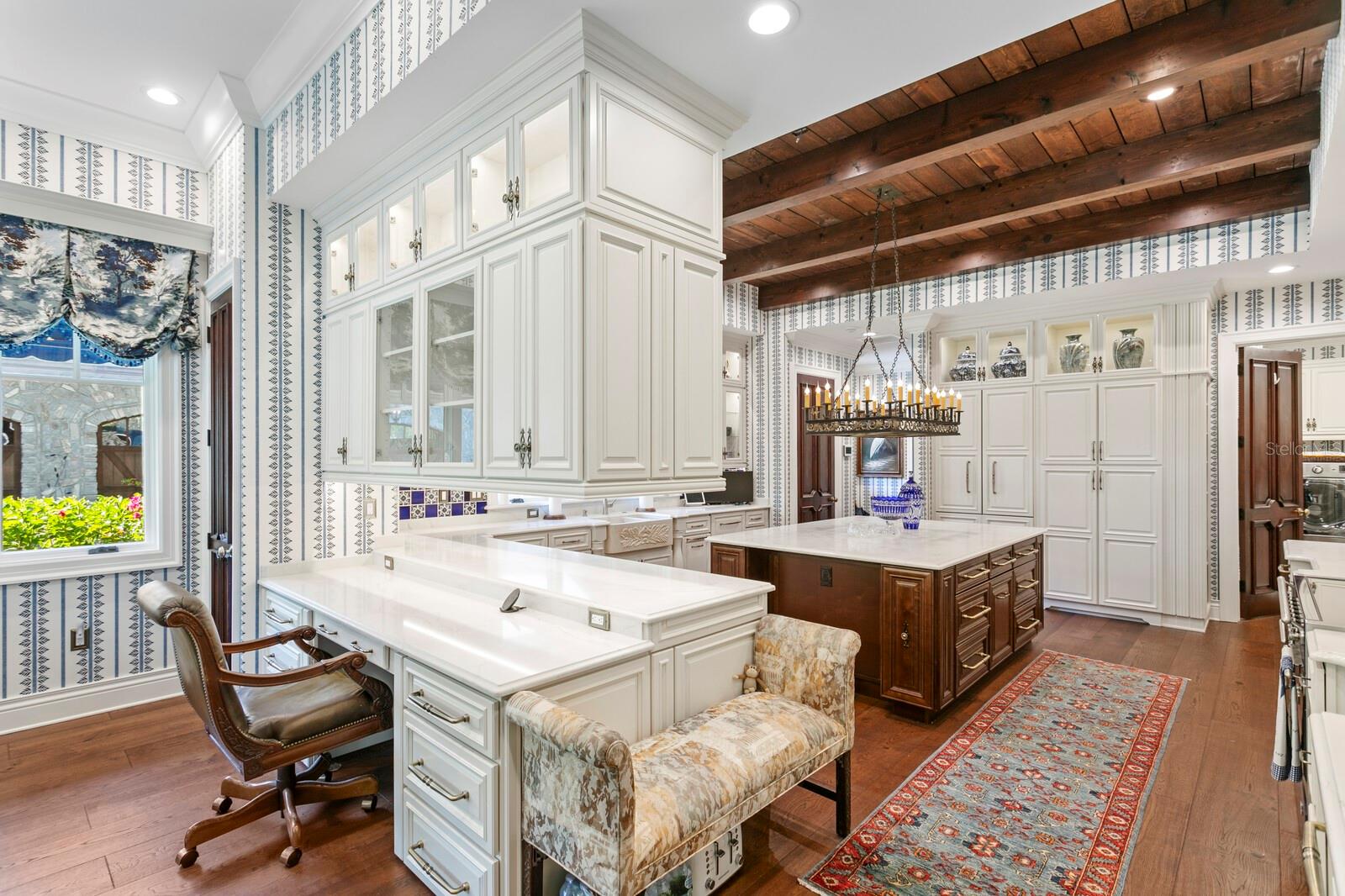 The custom cabinetry, is skillfully juxtaposed against rich, wooden beams, adding a rustic charm to the sophisticated ambiance.