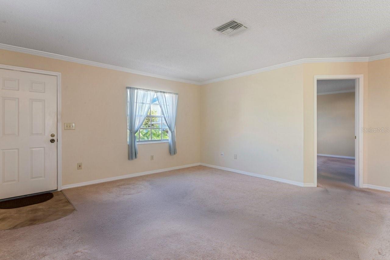Living room view and entrance to the primary bedroom.