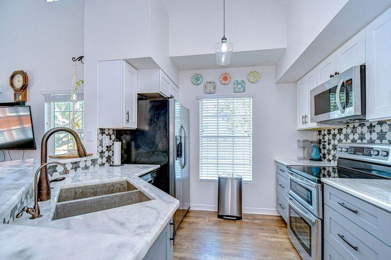 Upgraded Kitchen with Double oven, custom tile backsplash, stainless Microwave. Upgraded new cabinets.