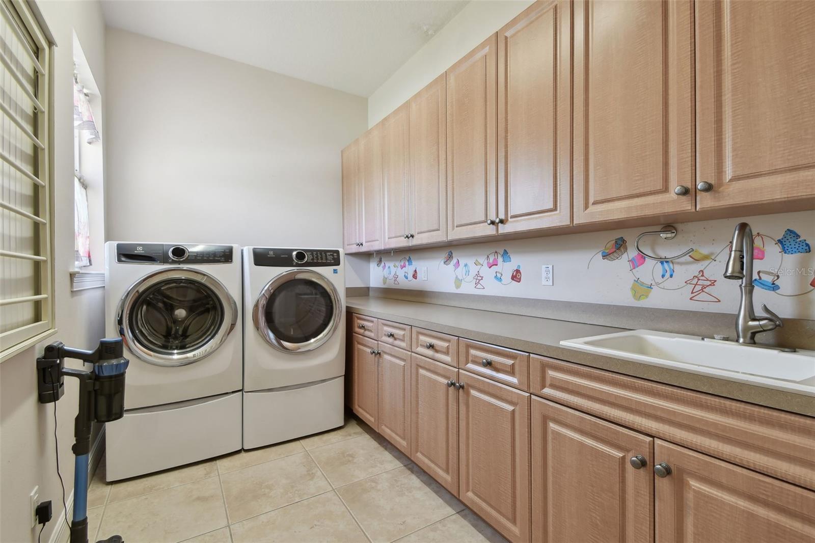 Laundry room with sink and an abundance of cabinetry.