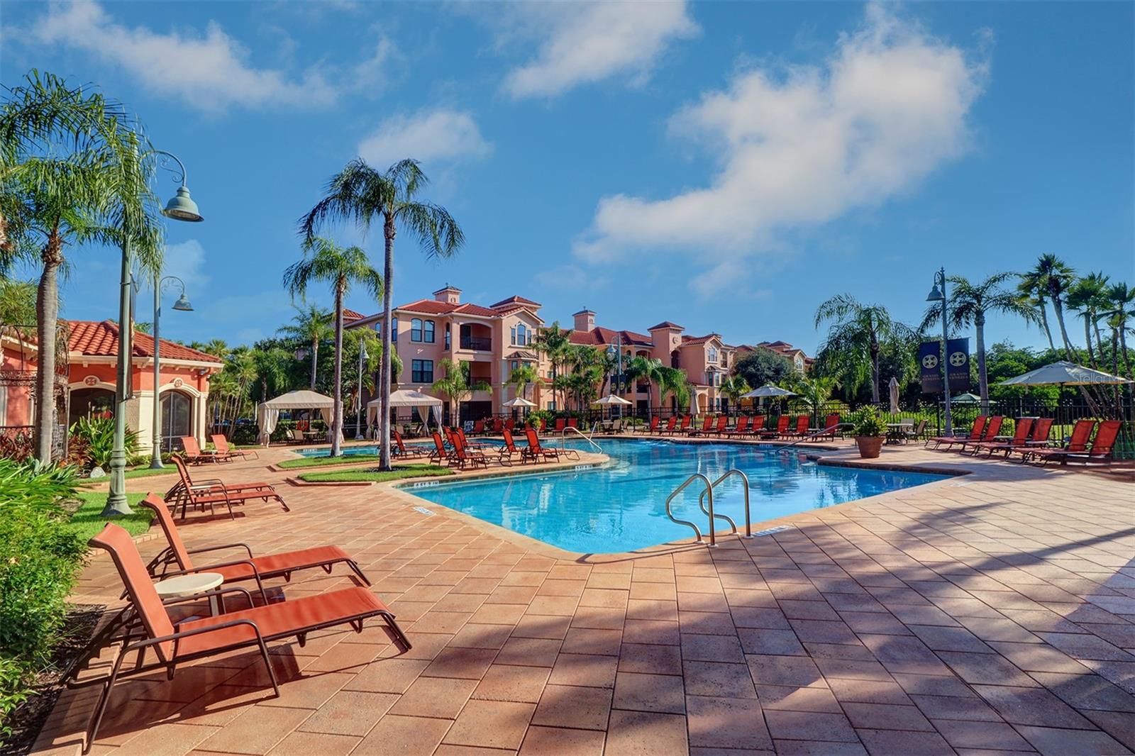 Pool decking and geo-thermal heated pool with cabanas, umbrella table and chairs