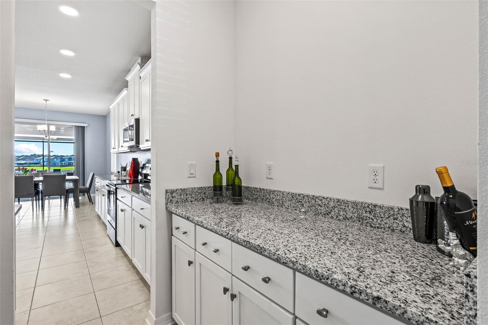Upgraded butler pantry with granite and cabinetry.