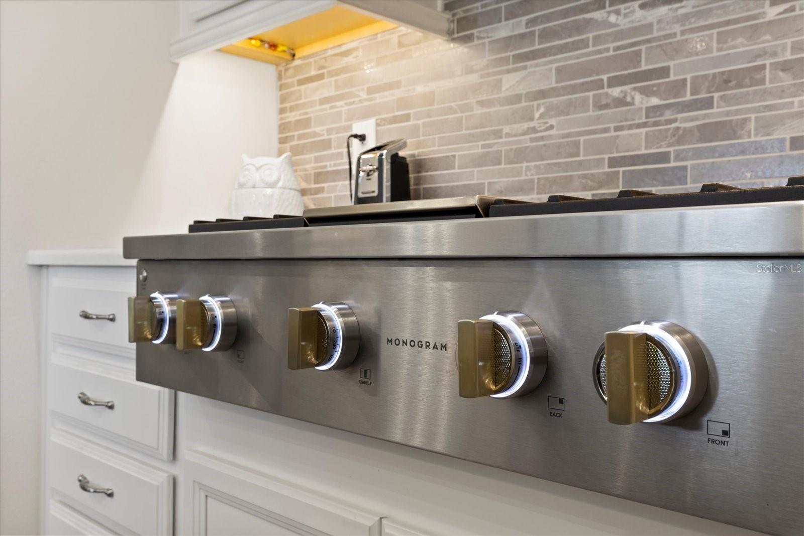 Monogram deluxe gas stove with warmer light and enhanced knob light features