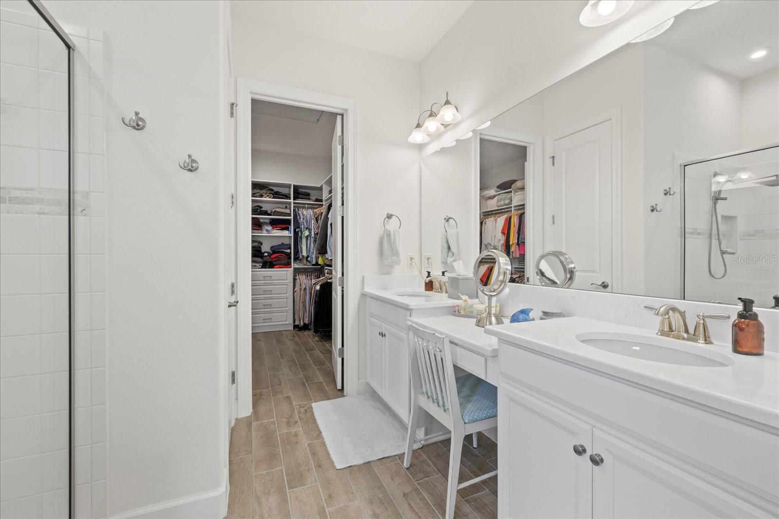 Dual vanity sinks with dressing table/chair in primary bathroom