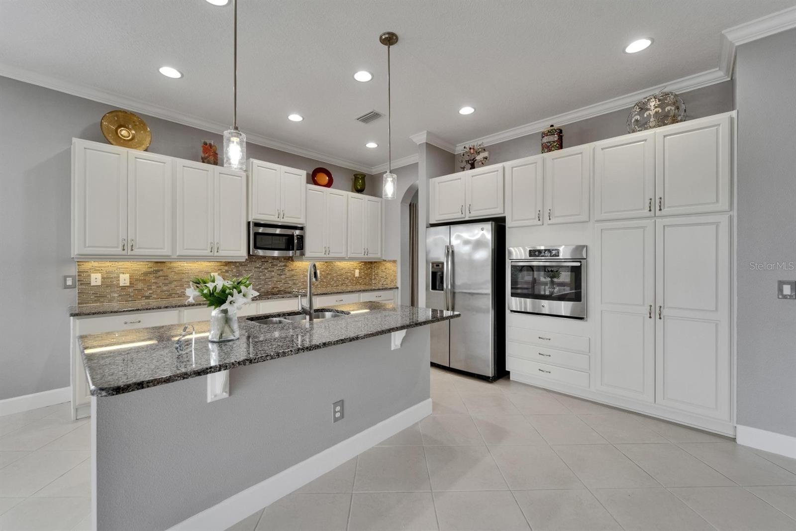 Kitchen features beautiful custom backsplash