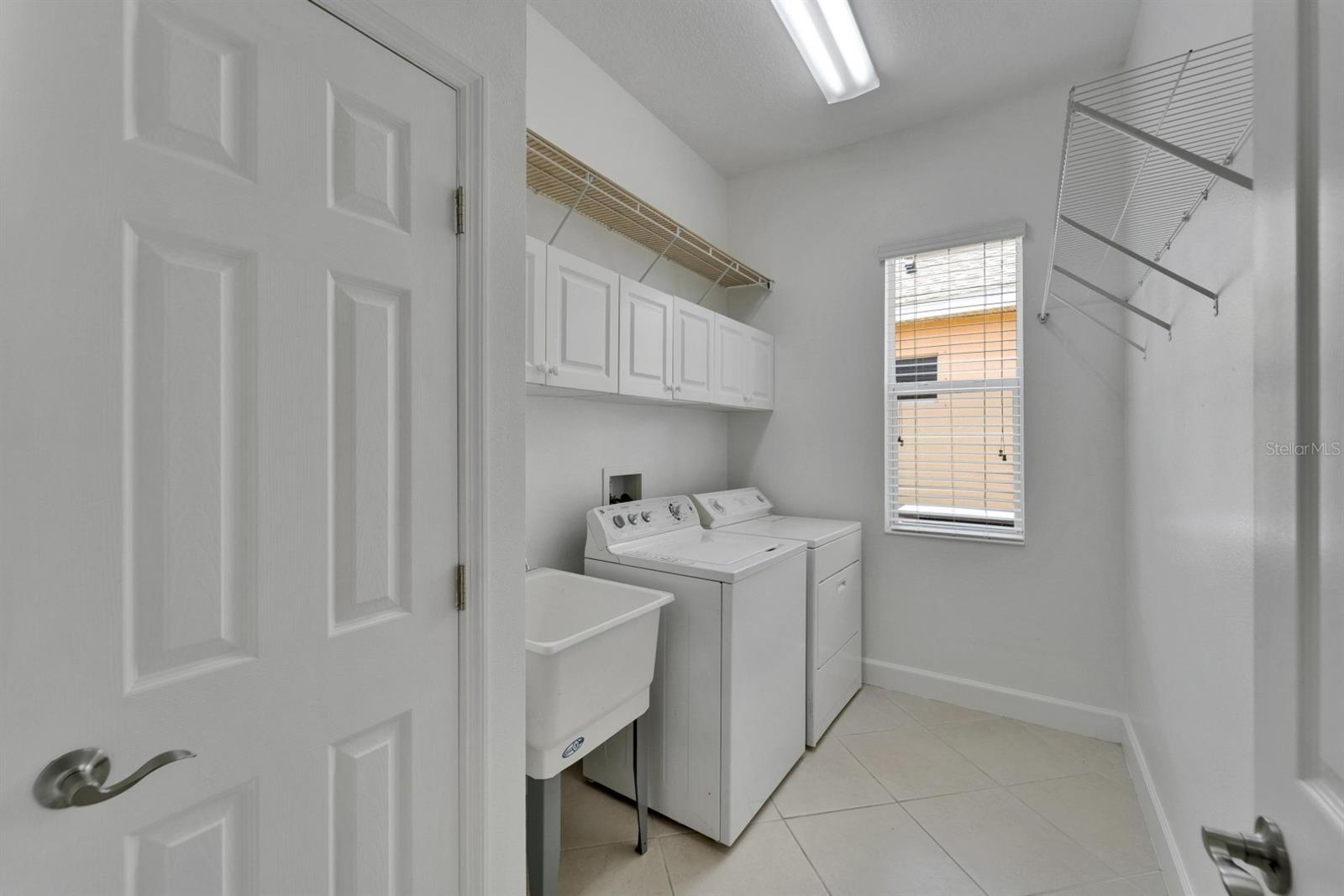 Dedicated Laundry room with washer, dryer, utility tub, extra storage cabinets, and coat_mop closet