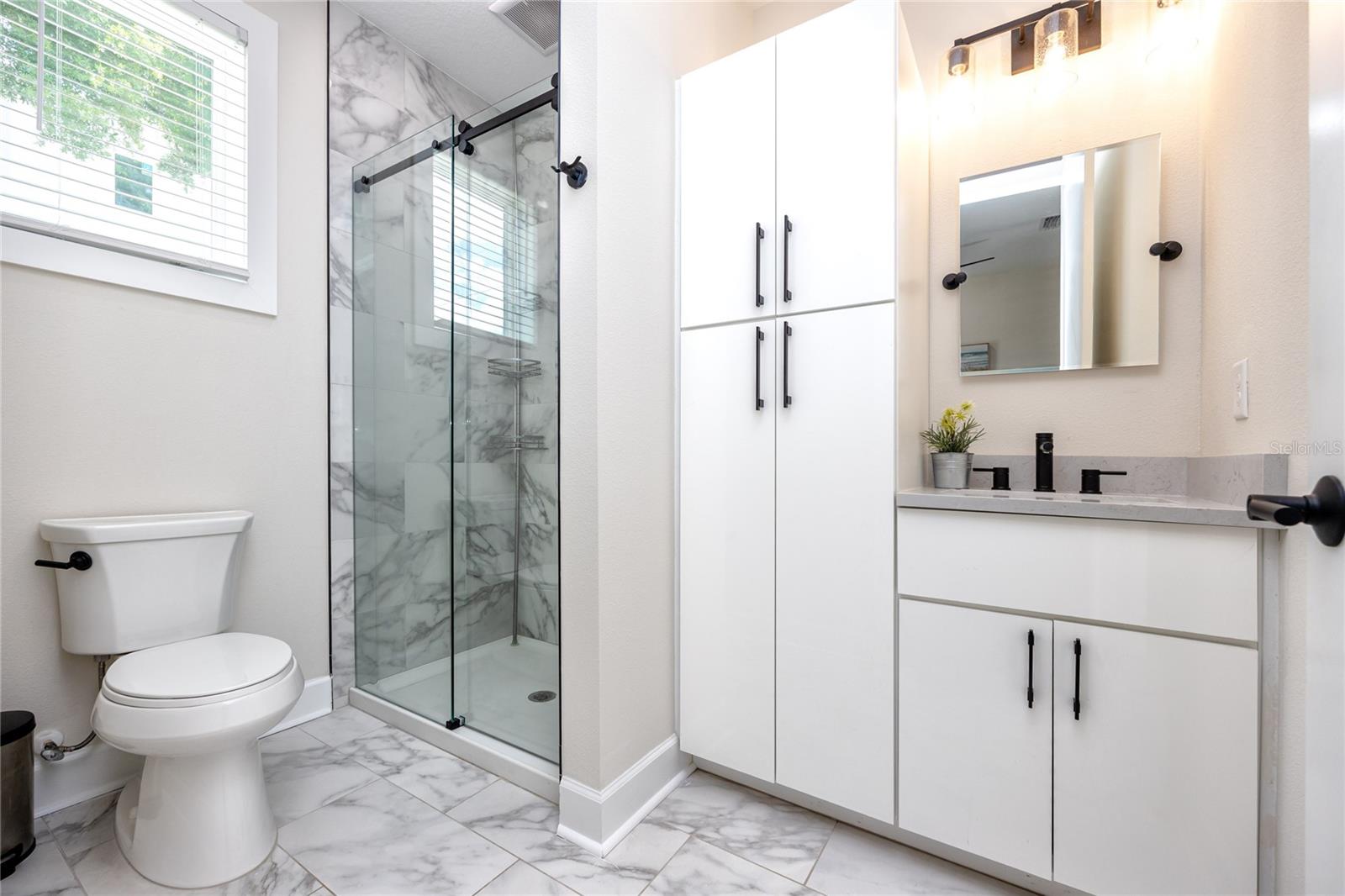 Full size bathroom adjacent to bedroom/den/office with a walk-in shower