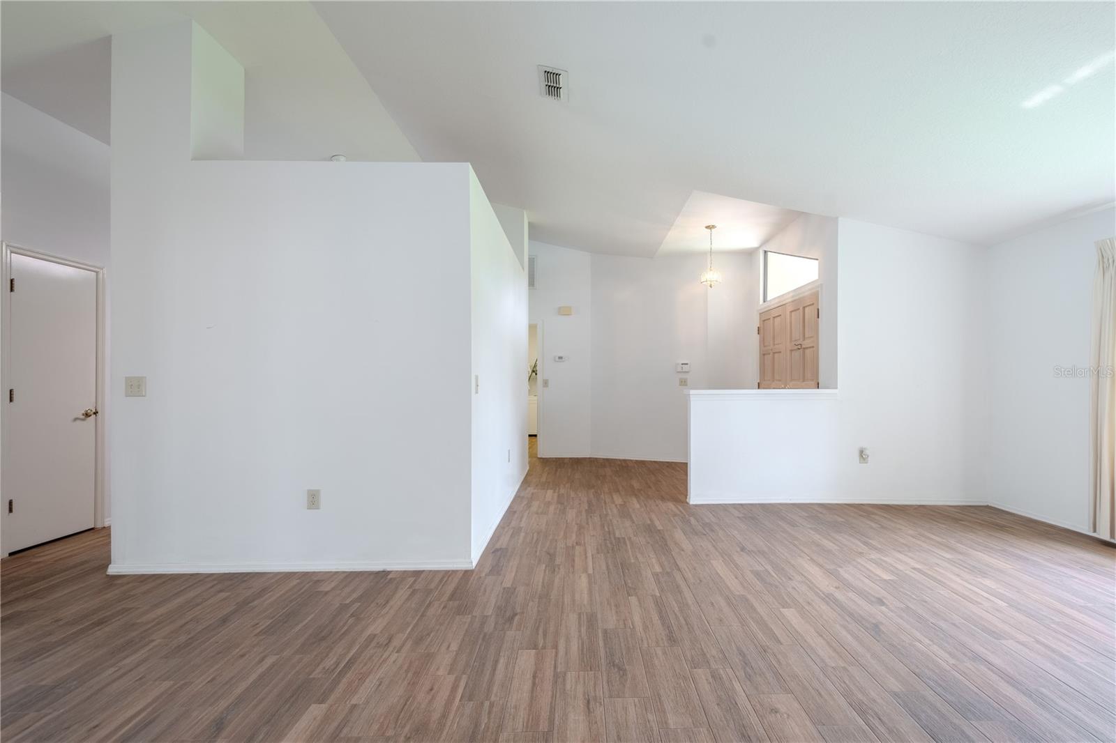 The continuous wood-look tile flooring adds warmth and cohesion, while the neutral walls make it easy to style to your taste.