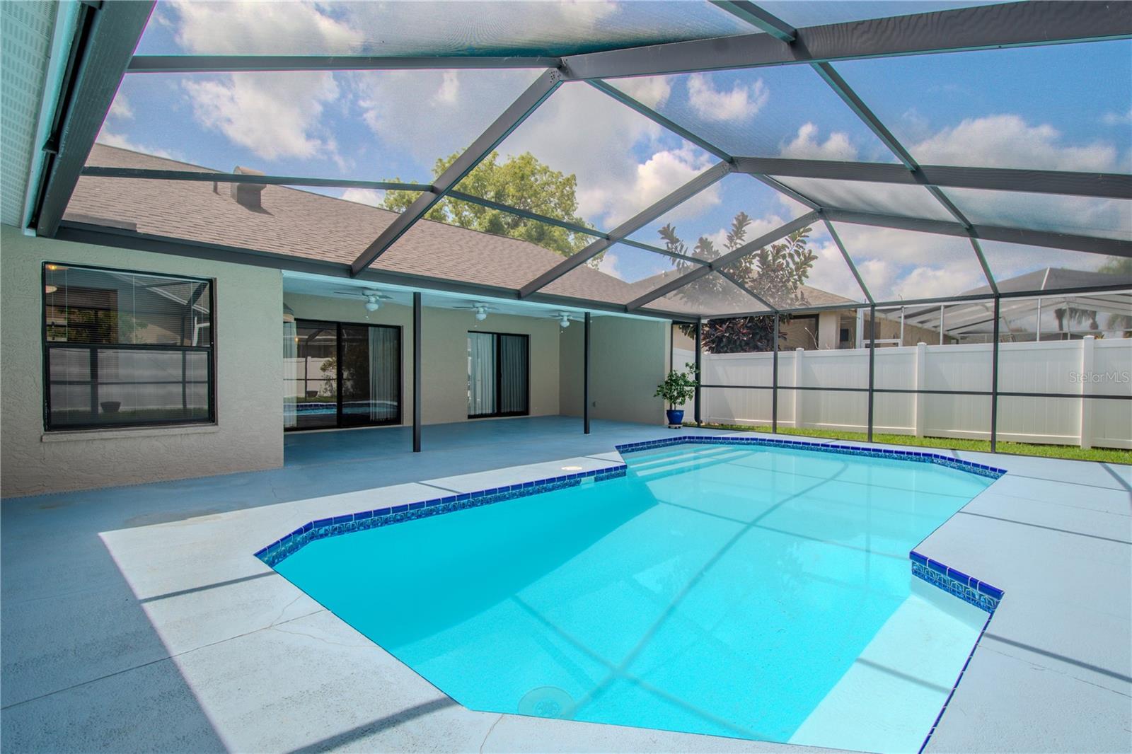 The screened-in lanai offers generous covered space for outdoor dining and lounging, complete with ceiling fans to keep you cool on warm Florida afternoons.