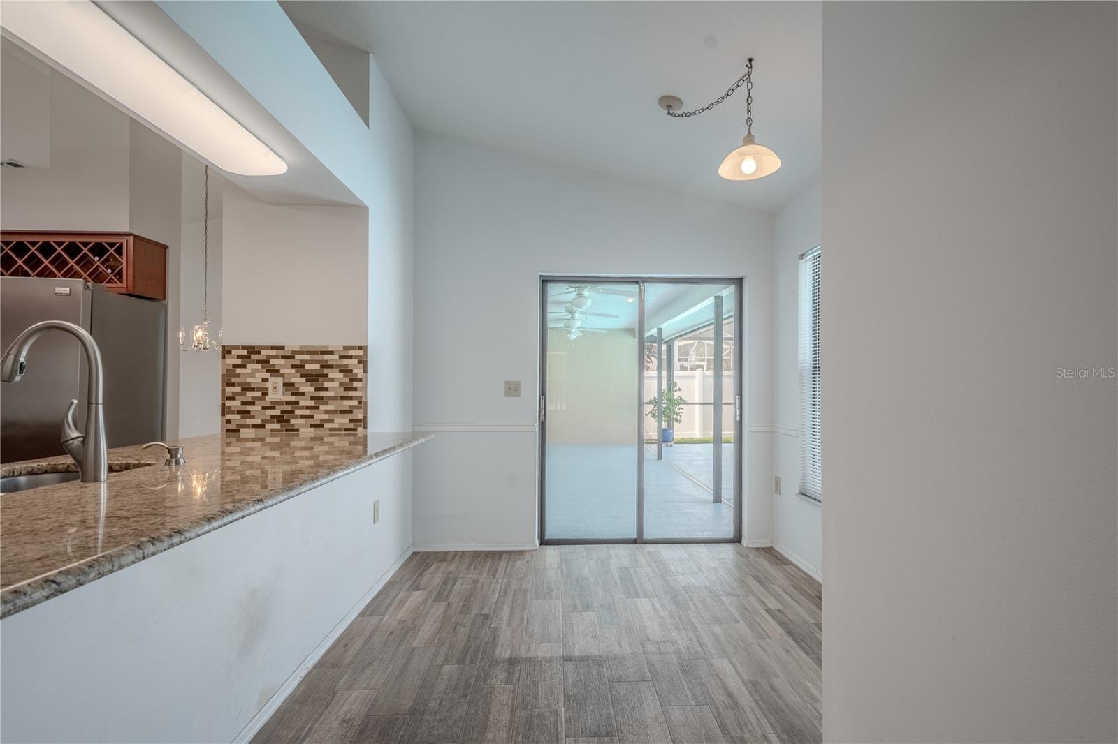 A long granite pass-through bar overlooks the pool and patio area, making this the perfect setup for indoor-outdoor entertaining.