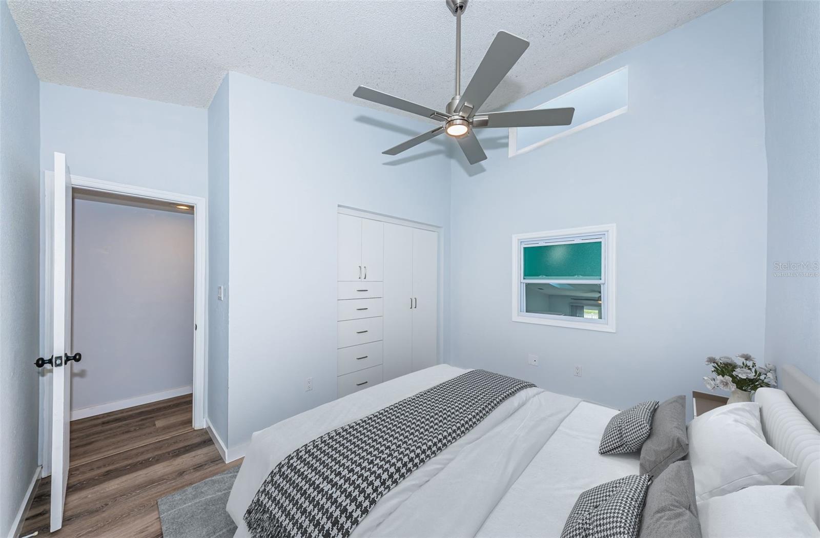 virtually staged: 2nd/guest bedroom w/ a newer fan, closet/drawers, window overlooking the main area & a clerestory window (has a velcro shade)