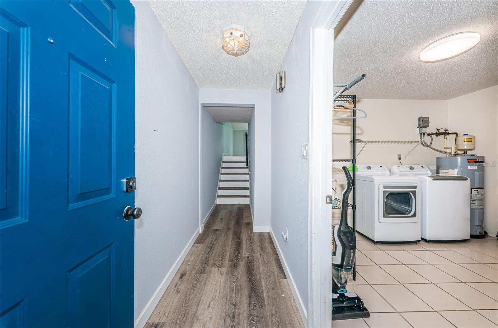 Foyer to stairs to main living area and the utility room