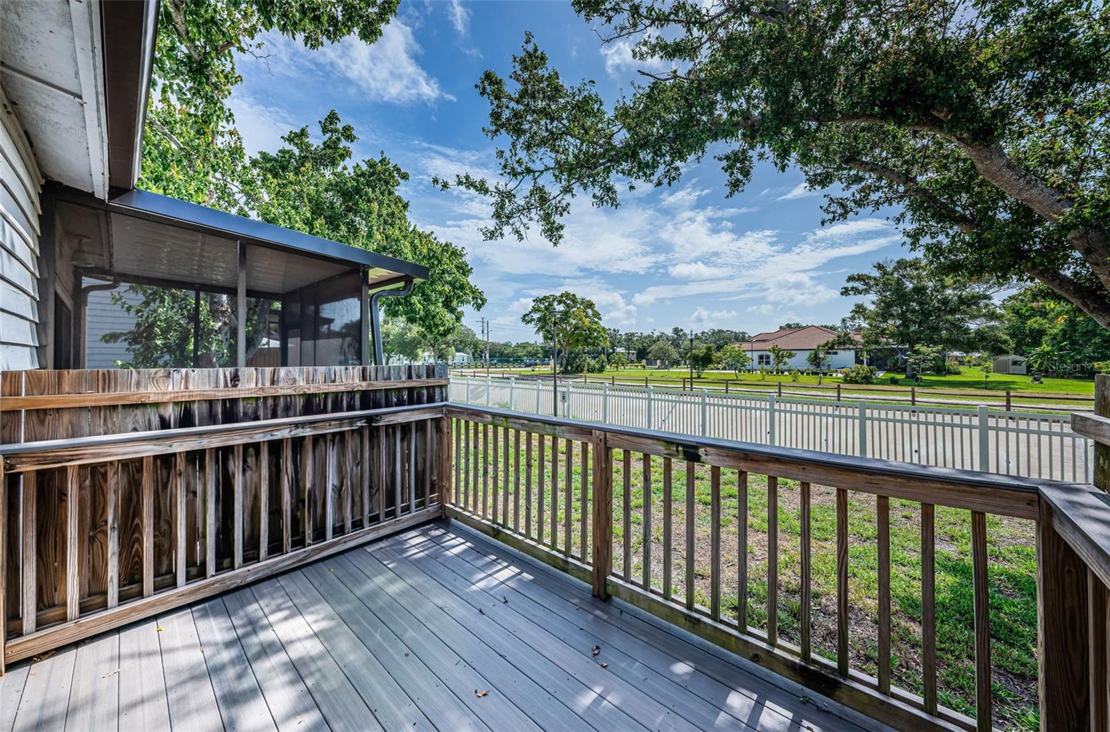 Rear porch w/ a horse trail beyond the fence