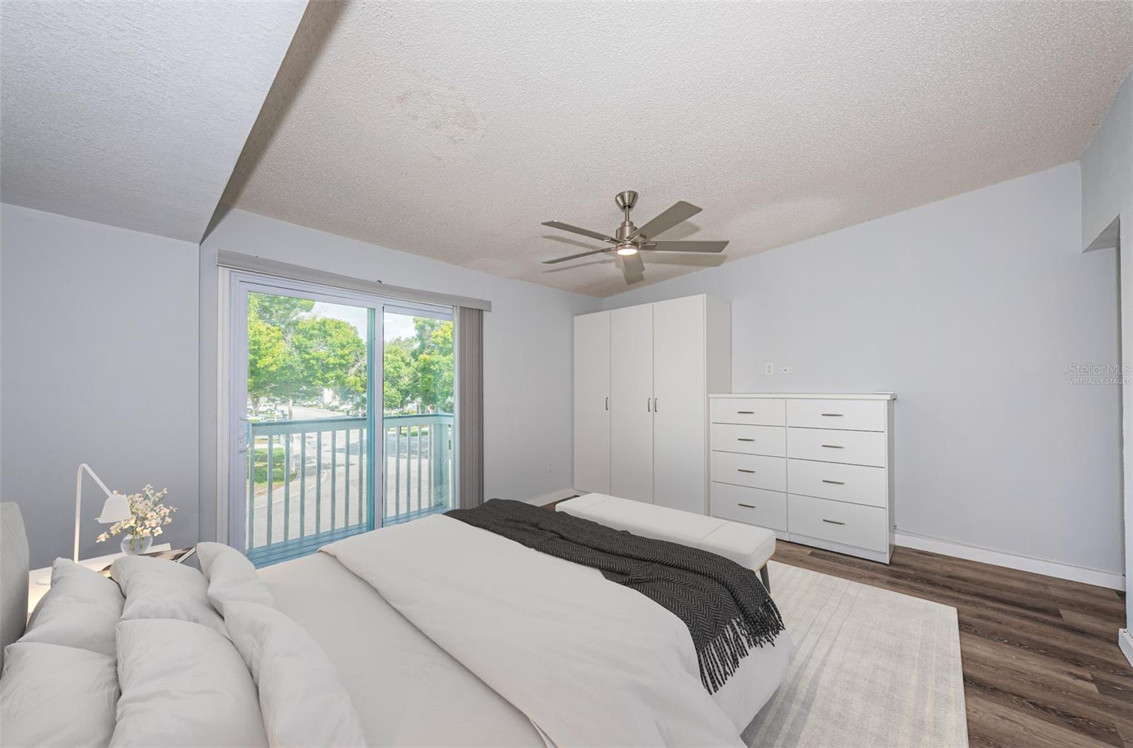 Virtually staged: Master bedroom w/ closet/drawers, newer fan & impact slider leading to front porch