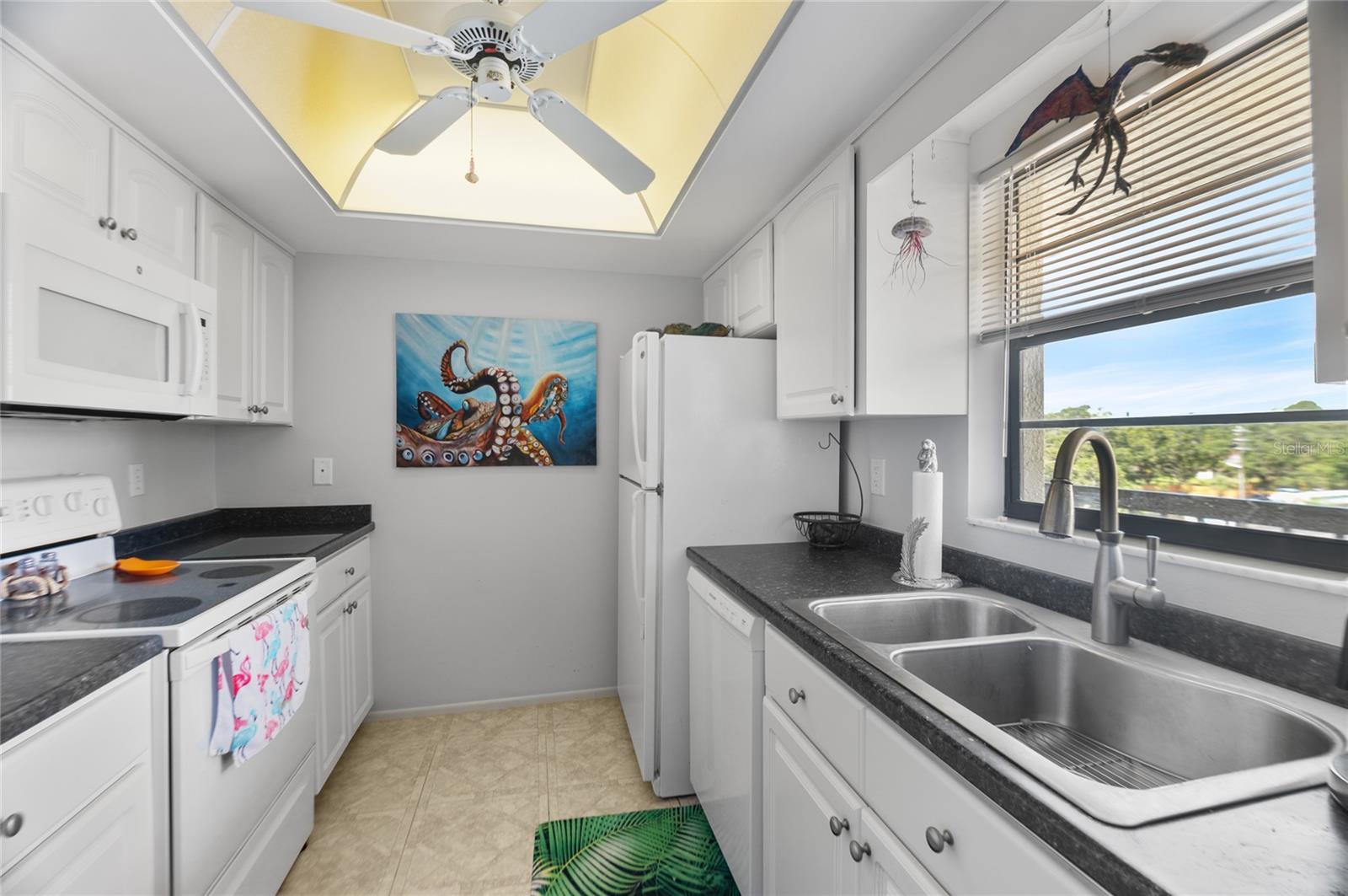 Kitchen has fridge, range, dishwasher, microwave, disposal, and a western view