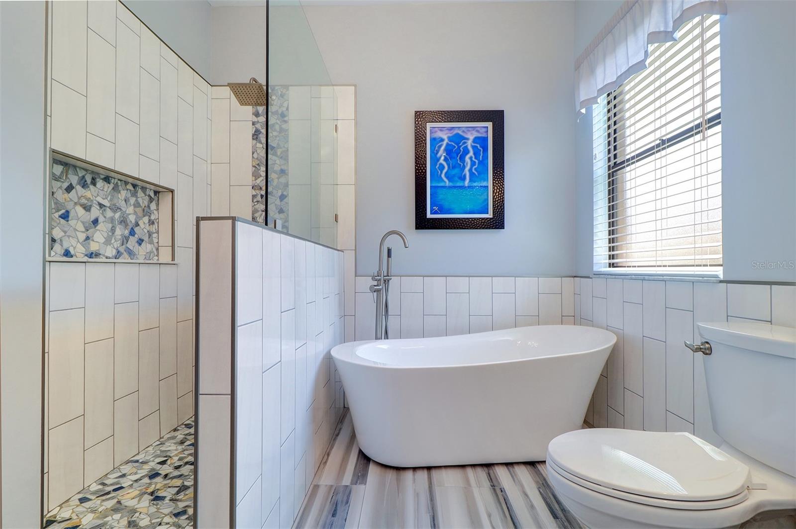 View of new tiled walk-in shower and stand alone garden tub