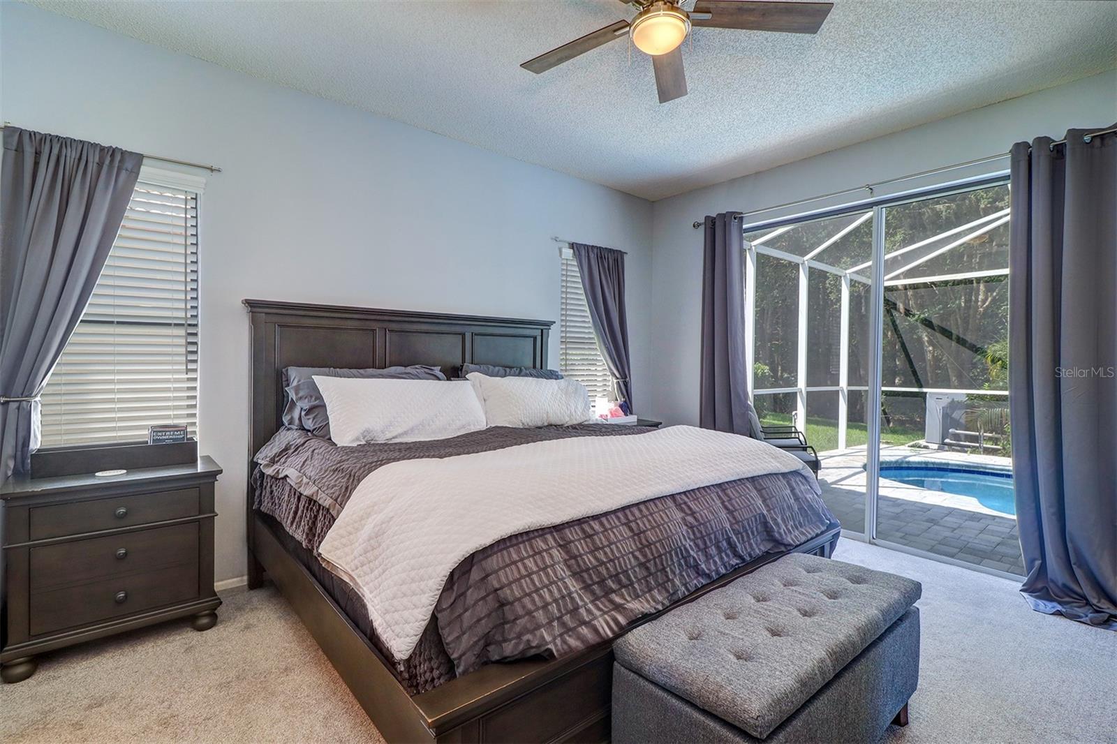 Primary bedroom with slider to deck and pool