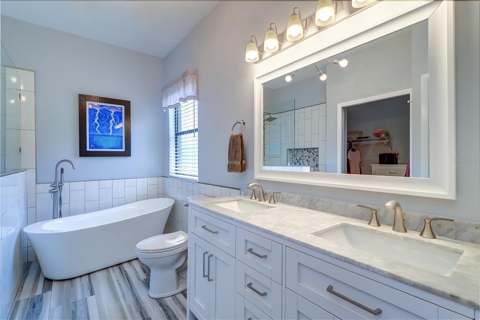 Primary bath with new dual vanity cabinet and mirror, stand alone garden tub