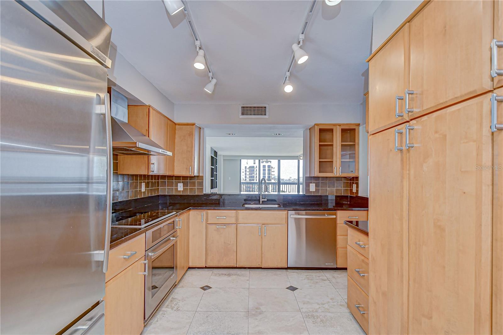 Designer kitchen with sleek granite counters and captivating bay views!