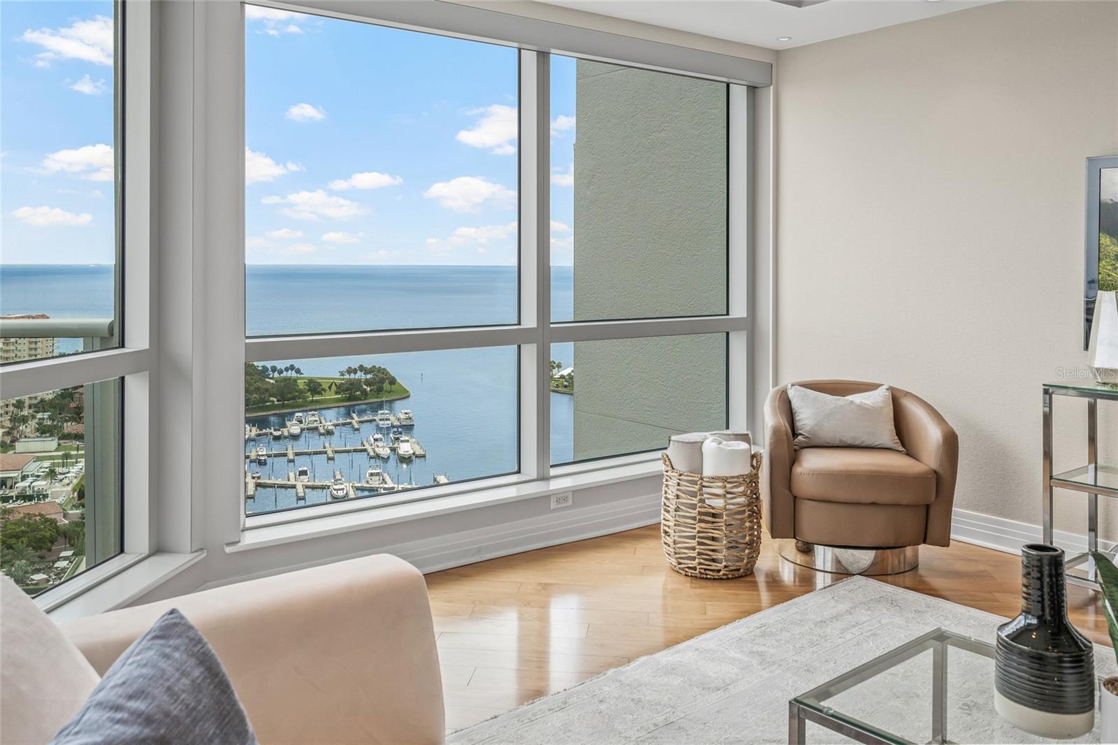 Wall-to-wall windows with bay views flood the living space with natural light.