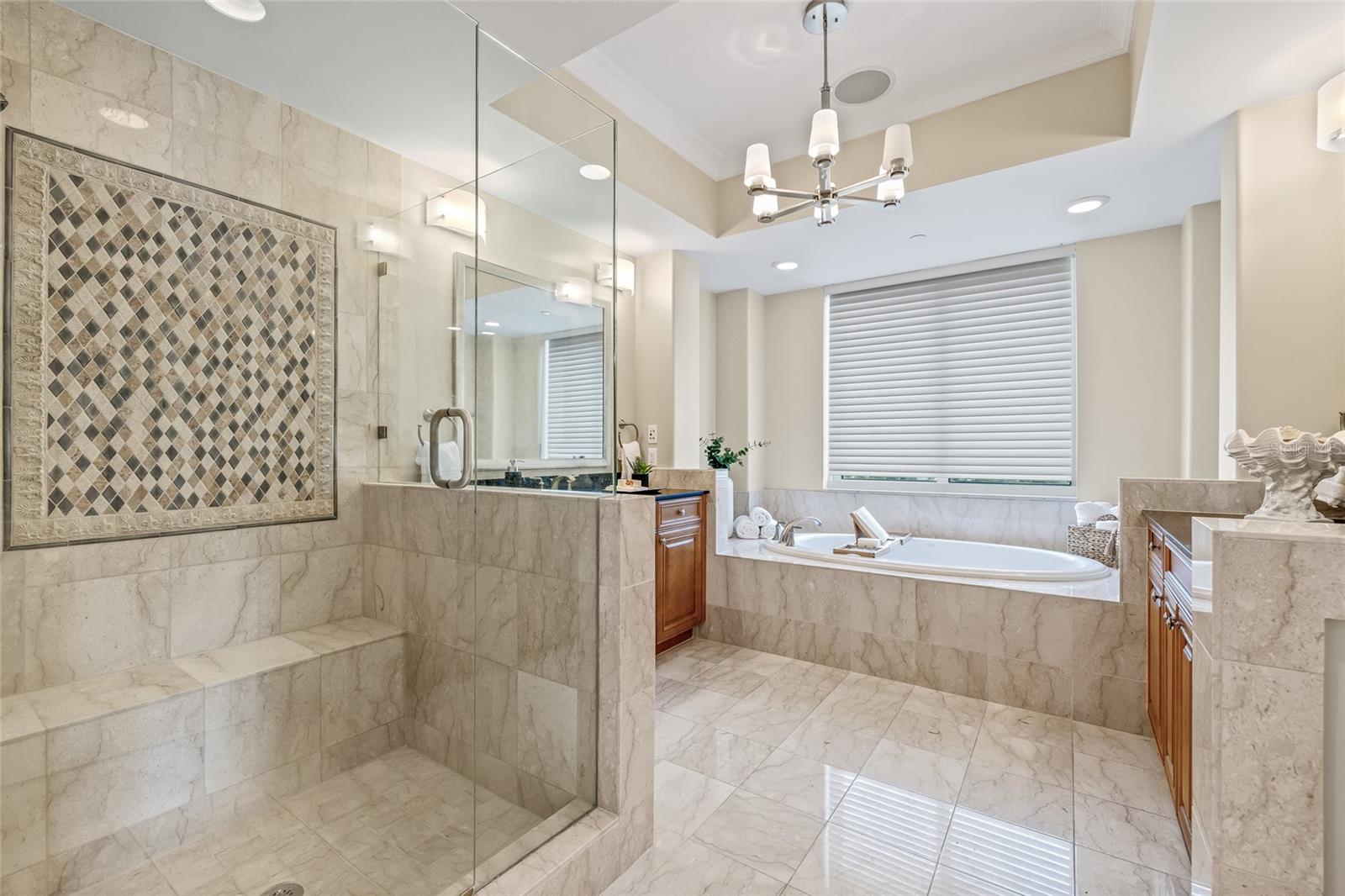 Primary bath with dual vanities, soaking tub, and walk-in shower.