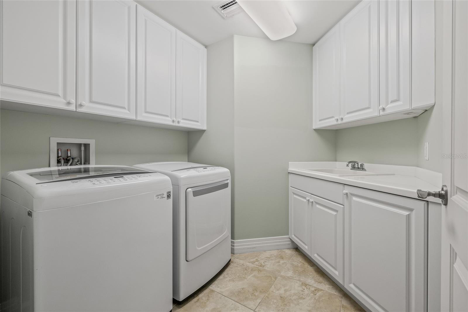 Dedicated laundry room with built-in cabinetry and a convenient utility sink.