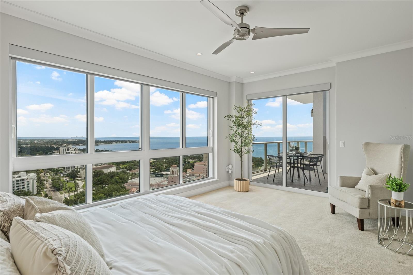 Wake up to sunrise over the water. The primary bedroom has direct access to the balcony through sliding doors.