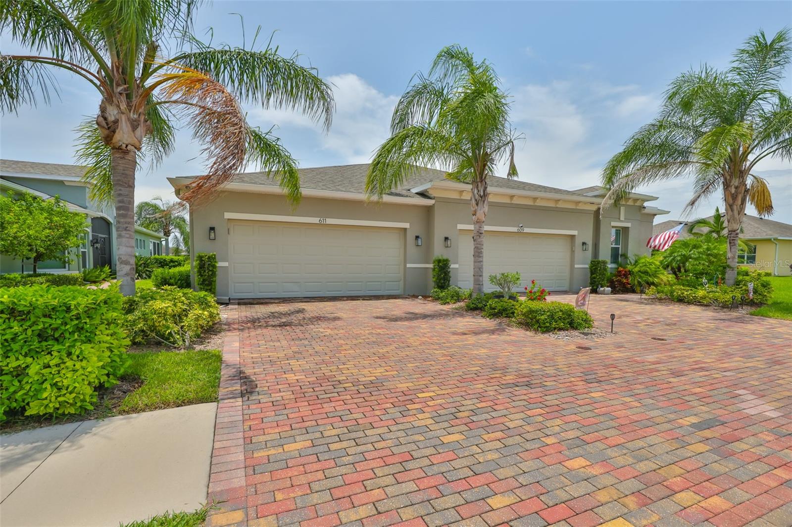 The large 2 car driveway with custom pavers and tropically landscaped, manicured front lawns are common throughout this neighborhood.
