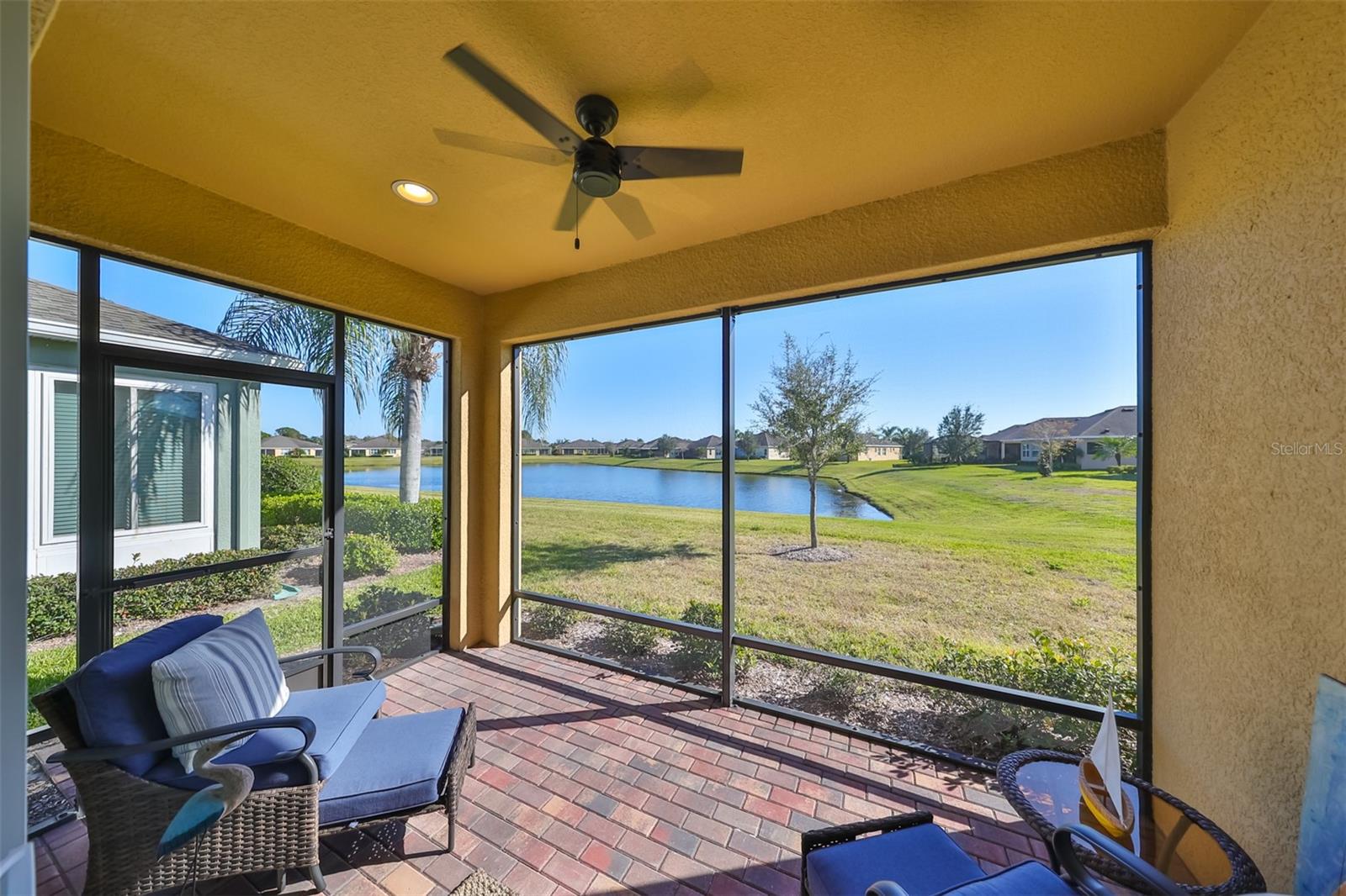 This is Florida living!! Private back screened enclosed lanai with ceiling fan, brick pavers and a water view.