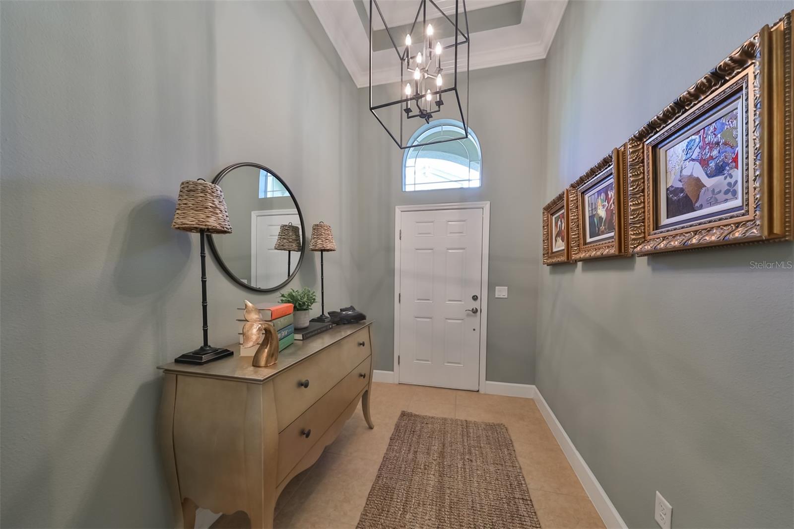 A large, oversized window above the door allows Florida sunshine to brighten the foyer.  High-end features, such as crown molding and trey ceilings are immediately evident.