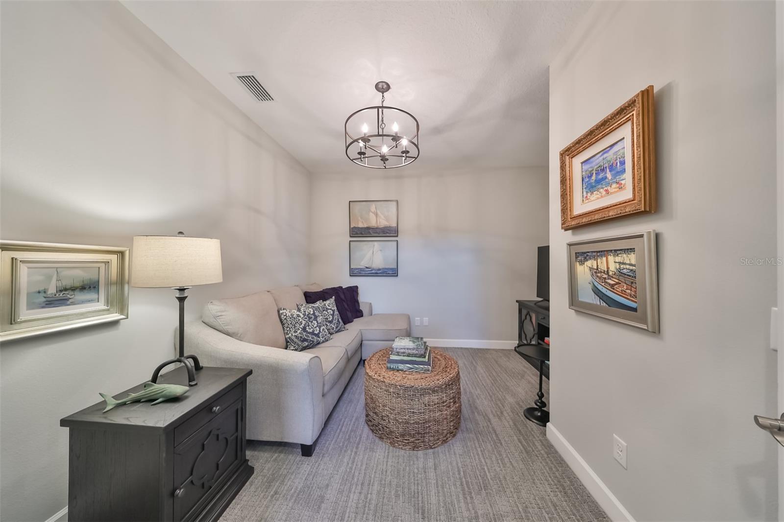 Matching chandeliers and lighting fixtures flow throughout the house.   The carpeting in this room helps to reduce any noise levels and you can already feel the contemporary 'coastal' theme decorating throughout the home.