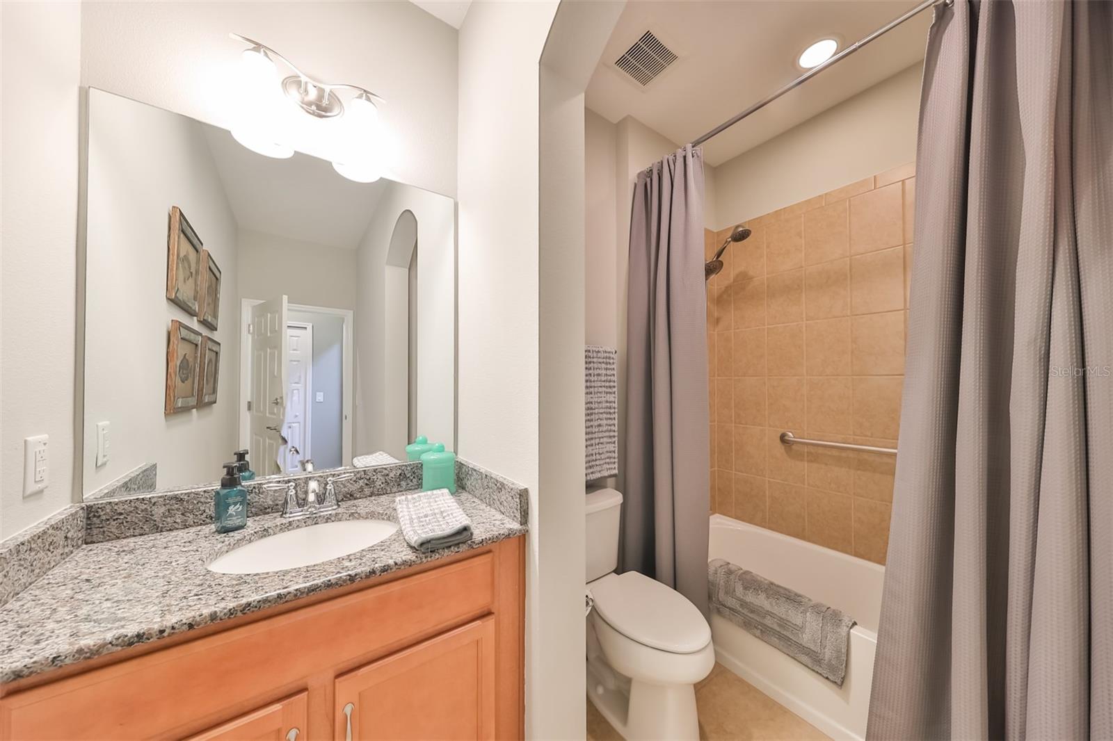 Guest Bathroom with updated matching sink and walk in tub/shower.  Again, arched entry ways give this home an architectural feel.