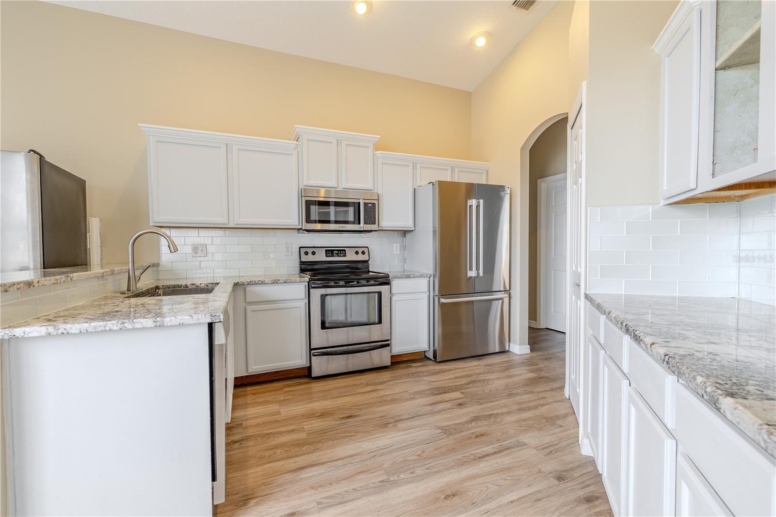 The warm wood cabinetry, granite counters, recessed lighting, and closet pantry bring style and convenience.