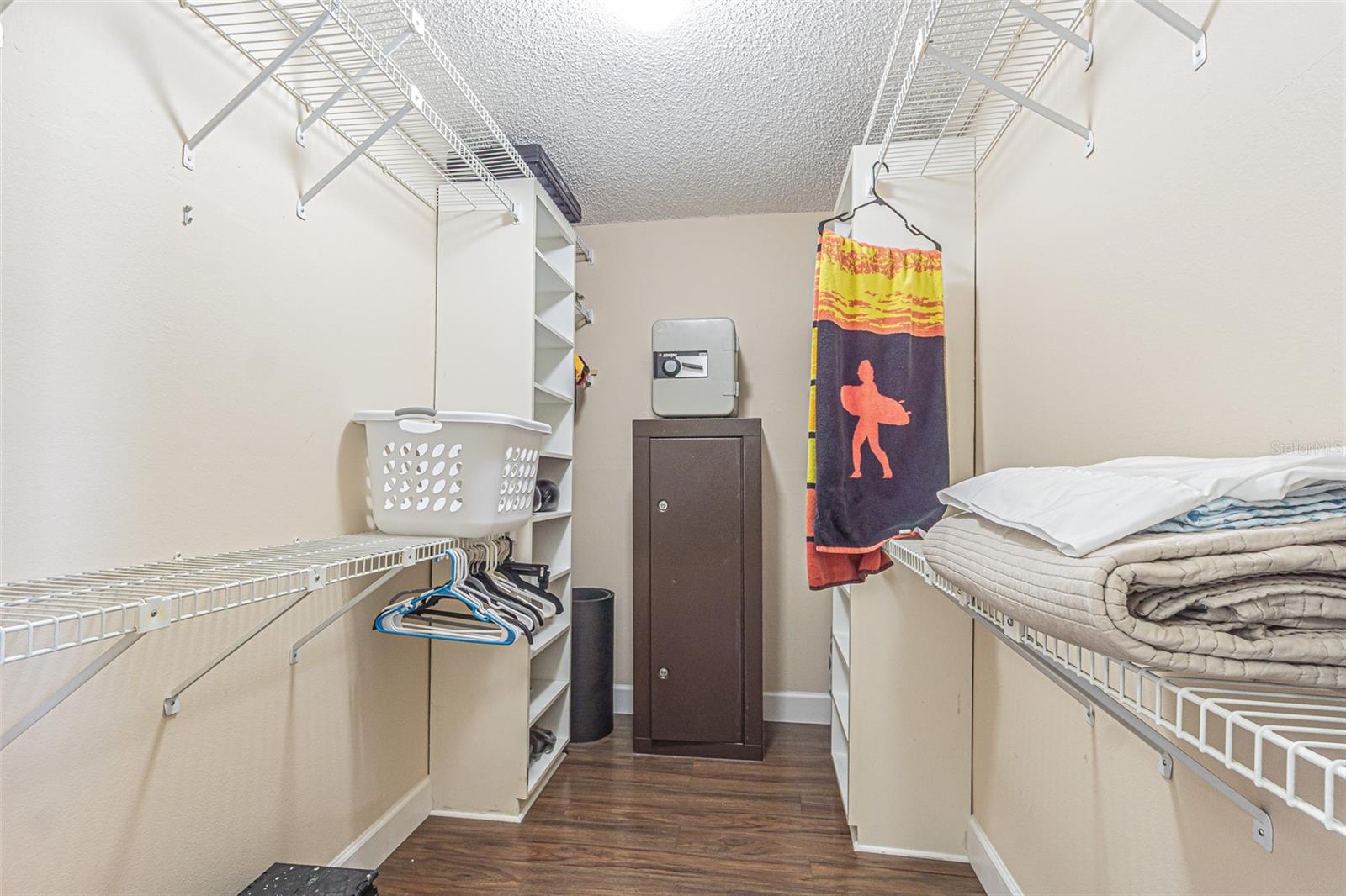 Walk in closet in owners retreat with bolted down safe