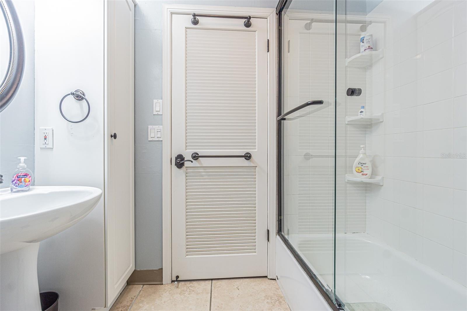 Pedestal sink and large shower in tiled hall bath