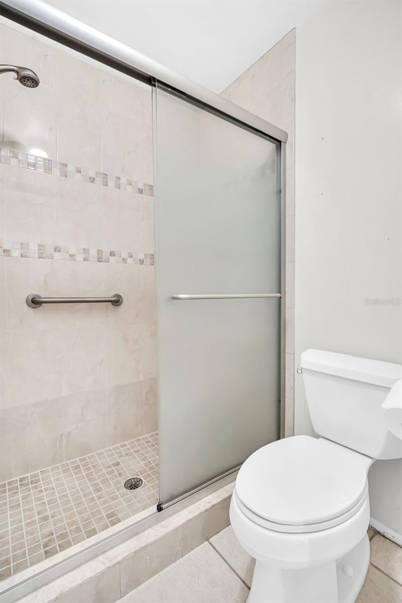 Walk-in shower with grab bars for safety~