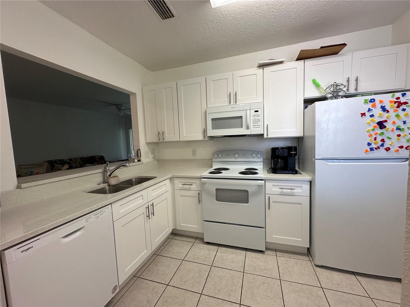 Coarse counter top and allwood white cabinets.