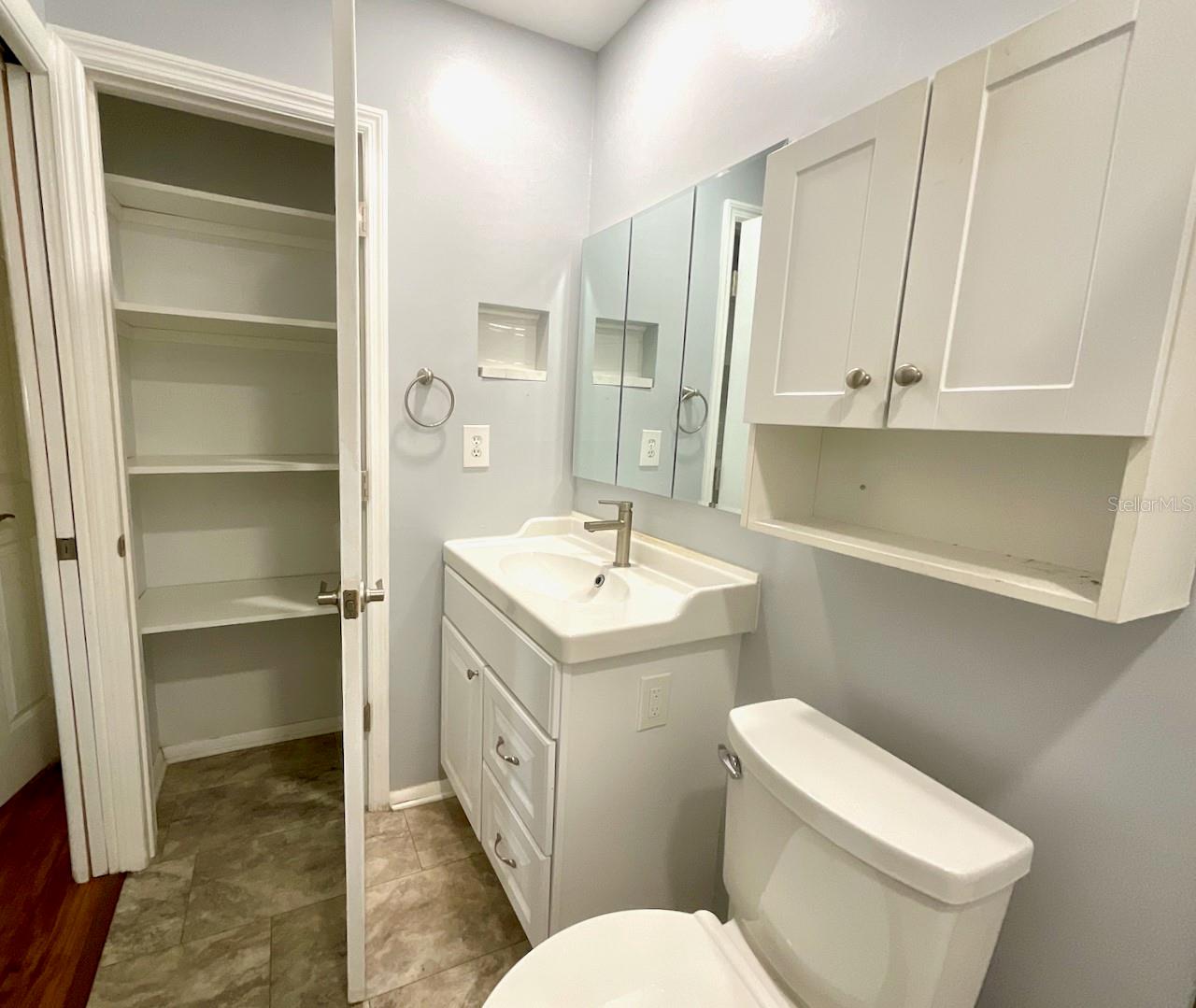 Primary bath sink area with linen closet