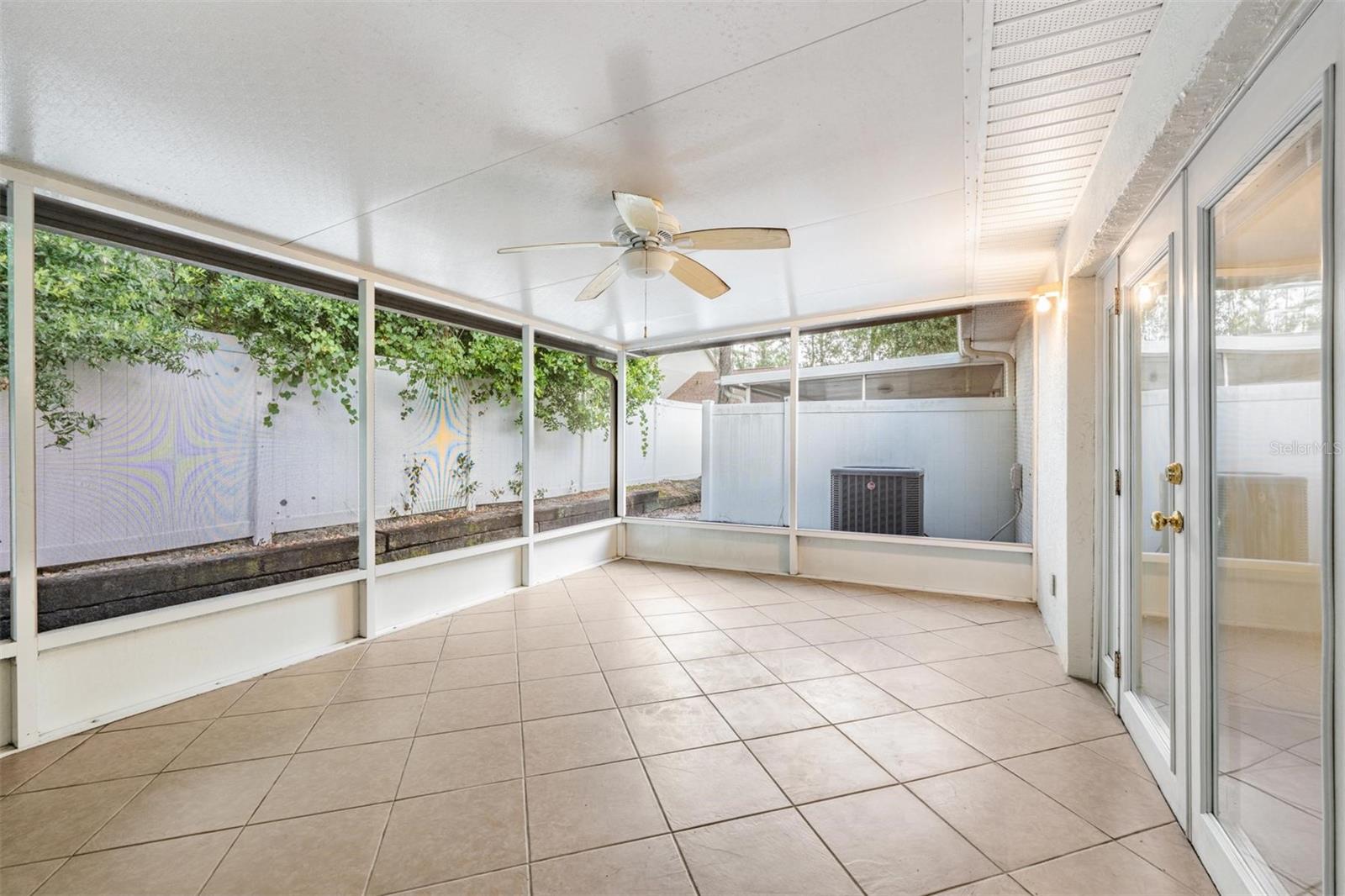 Large back patio, tile flooring, ceiling fan.