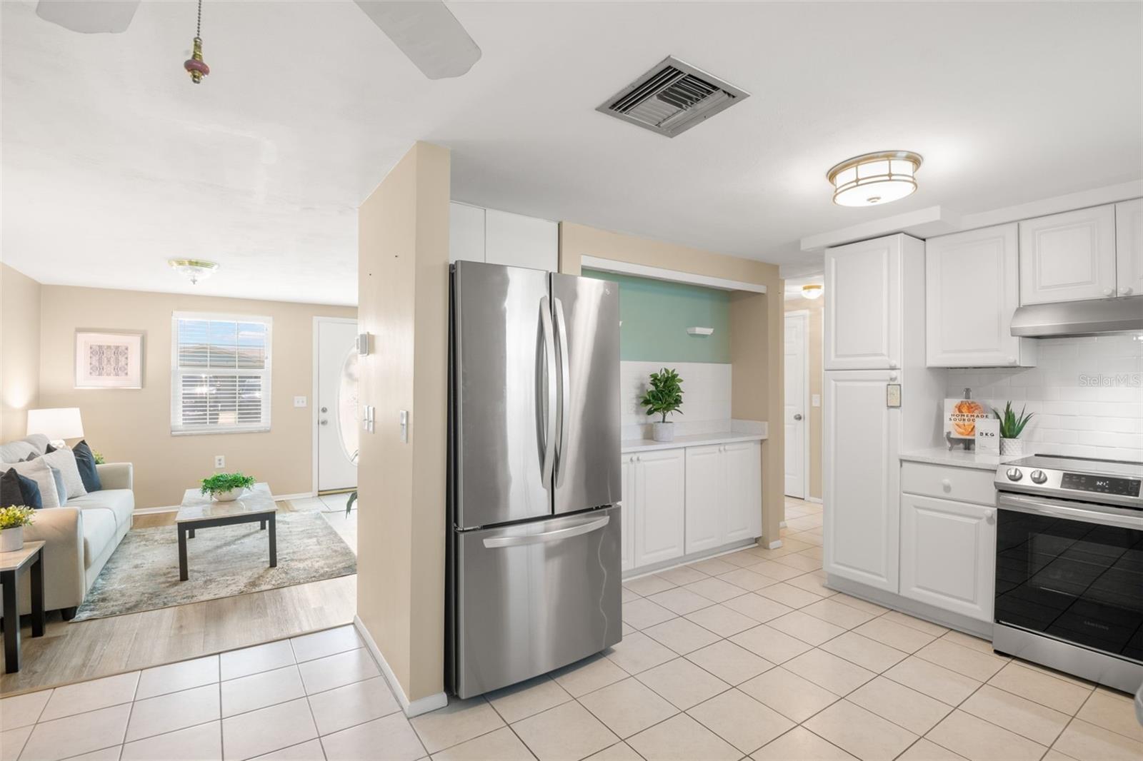Spacious kitchen with quartz counter tops, pantry and beverage or serving bar
