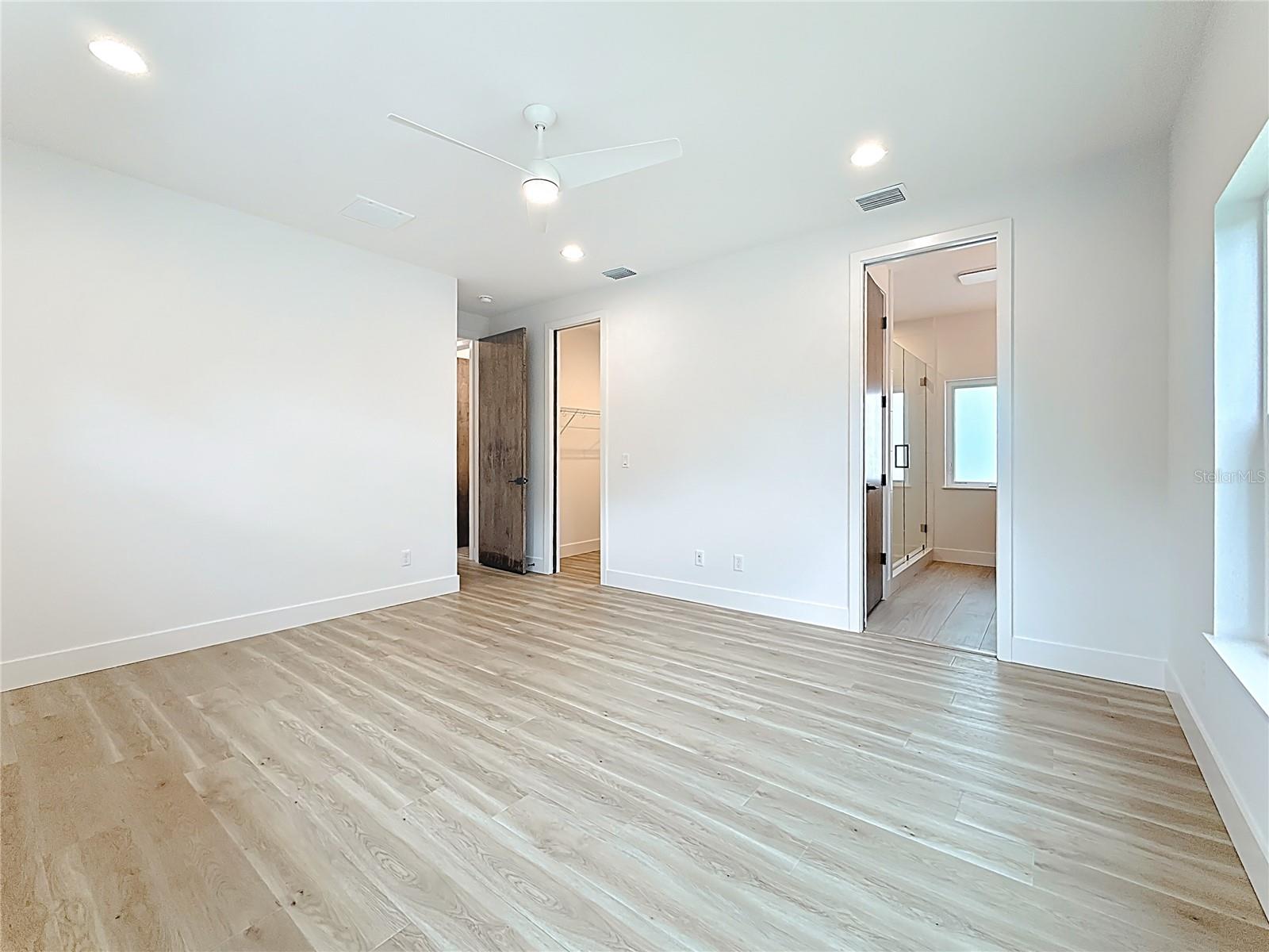 Elegant Primary Bedroom upstairs featuring a sleek en suite bath and abundant natural light.